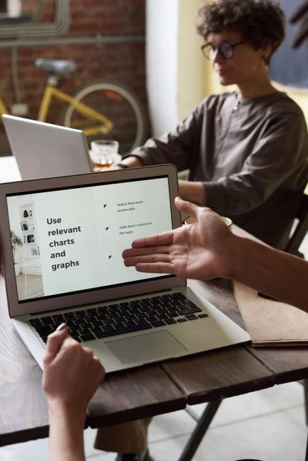Team members discussing digital graphs on a tablet in a modern office setting.